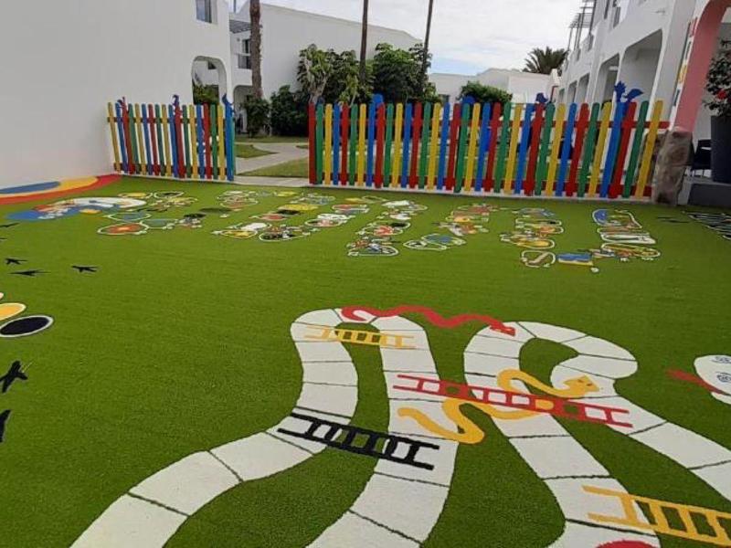 Barevné venkovní hřiště s hrami Malefiz a Člověče, nezlob se na zeleném umělém trávníku