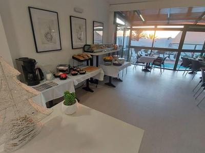 Modern hotel restaurant with large windows and water view at sunset.