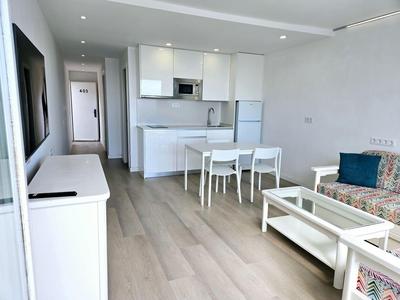 Helle, moderne Wohnung mit offener Küche, Esstisch und Sofa im Wohnzimmer.