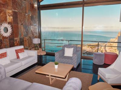 Moderner Wohnzimmerbereich mit großen Fenstern und Meerblick in einem Hotel.
