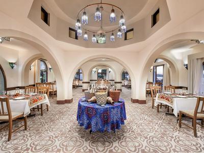 Ristorante elegante con tavolo rotondo al centro e tovaglie bianche sotto soffitto a volta.