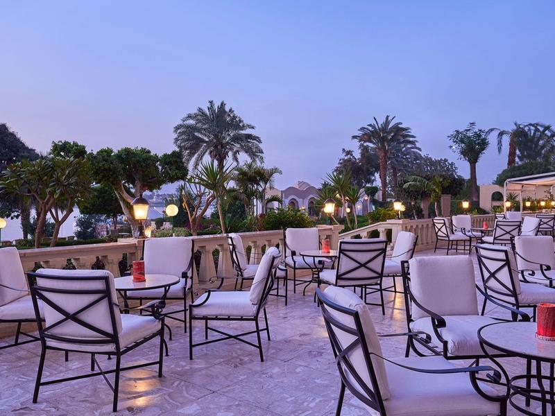 Terrazza esterna con sedie e tavoli al crepuscolo.