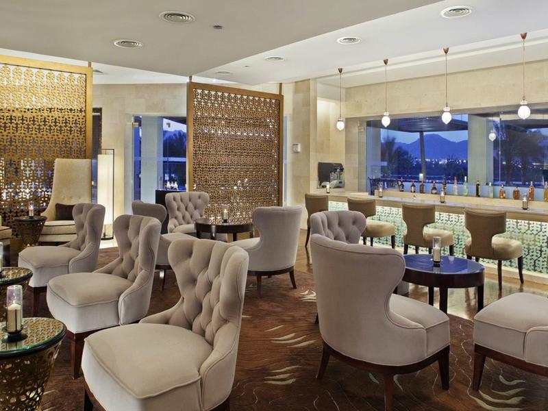 Eleganter Hotel-Loungebereich mit bequemen Sesseln, Tischen und großem Fensterblick.