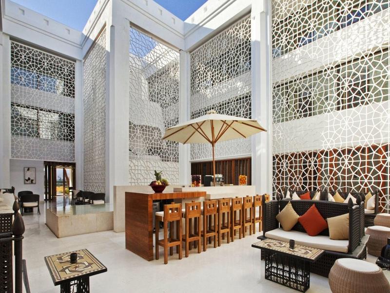 Moderner Innenhof mit Bar, Sitzgelegenheiten und dekorativen Wänden in einem Hotel.