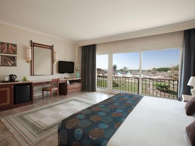 Modernes Hotelzimmer mit Doppelbett und großem Fenster mit Blick auf die Stadt.