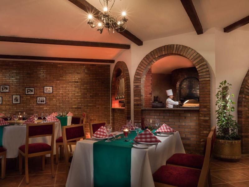 Cozy restaurant area with wooden beams, brick walls, and decorative table settings.