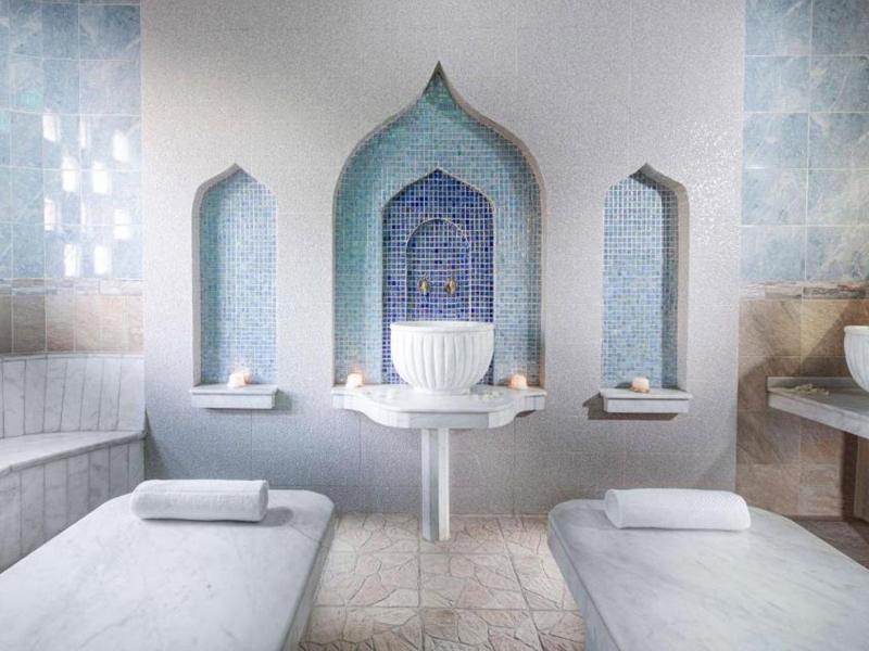 Spa moderno con lettini bianchi, nicchie di mosaico e atmosfera tranquilla