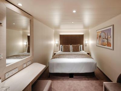 Gemütliches Hotelzimmer mit Doppelbett, großem Spiegel und Wandbild.