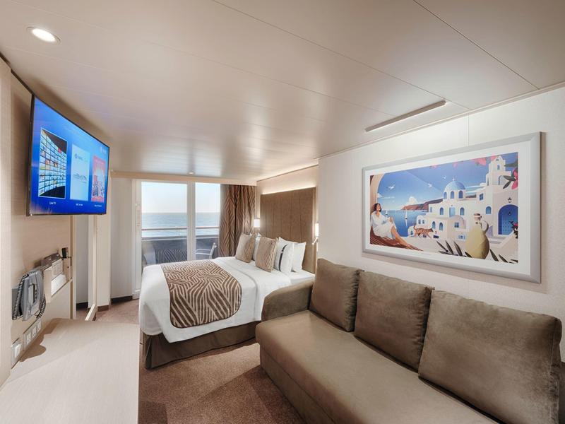 Modernes Hotelzimmer mit Doppelbett, Sofa, TV und Meerblick.