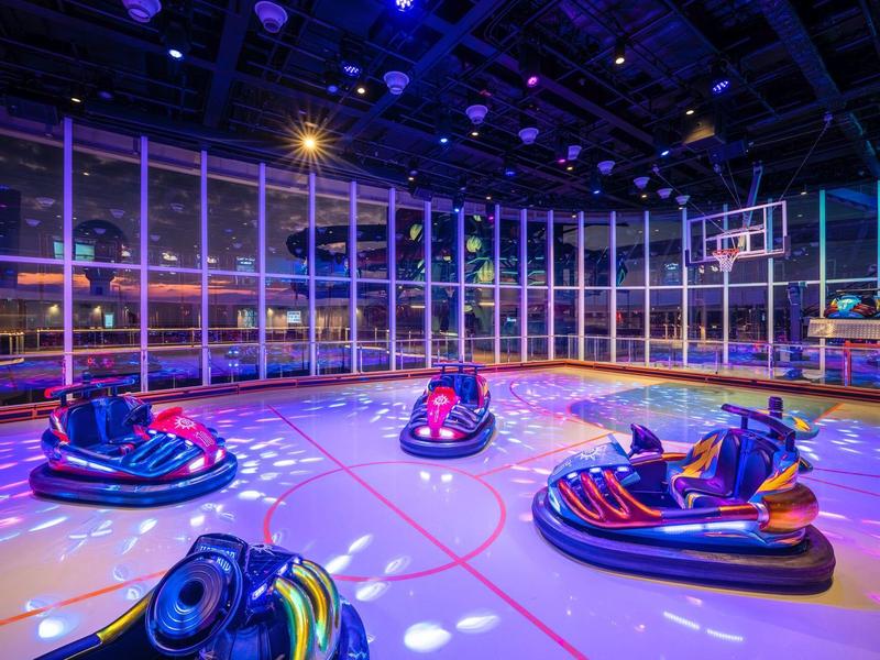 Bunte Bumper Cars in einer gut beleuchteten Halle mit Basketballkorb.