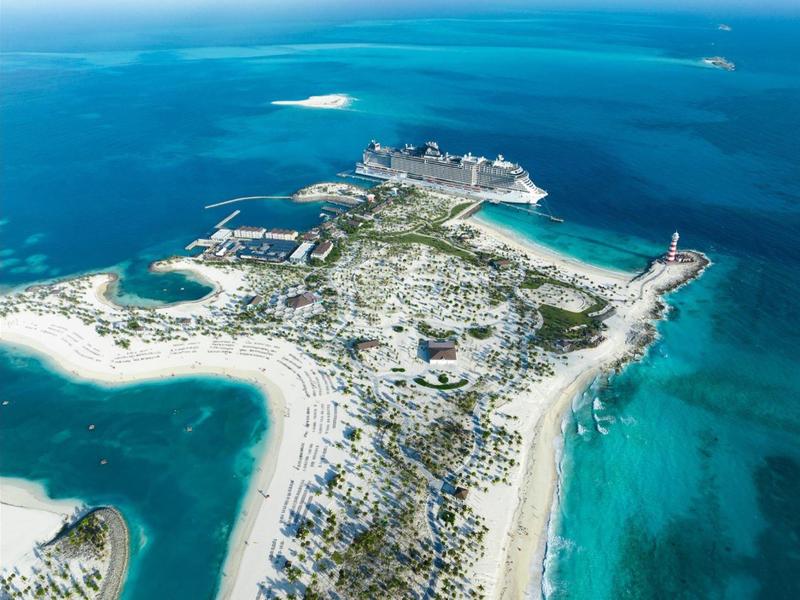 Luftaufnahme einer tropischen Insel mit Stränden und Kreuzfahrtschiff im türkisfarbenen Wasser.