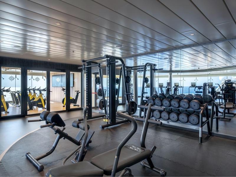 Moderne Fitnessraum mit Kraftgeräten und Hanteln in einem Hotel.