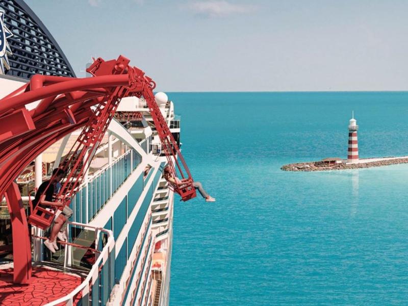 Schiff mit rotem Kran am Bug, Leuchtturm auf einer kleinen Insel im türkisfarbenen Meer.