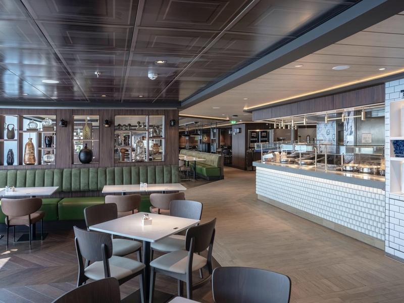 Moderner, offener Restaurantbereich mit Tischen, Stühlen und einer langen Theke.