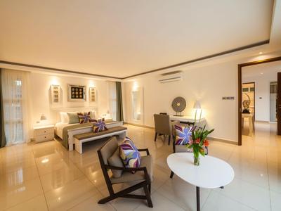 Helles Hotelzimmer mit zwei Betten, Sitzecke und eleganter Einrichtung.