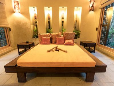 Modernes Hotelzimmer mit großem Bett, Deckenbeleuchtung und zwei Fenstern mit Blick ins Grüne