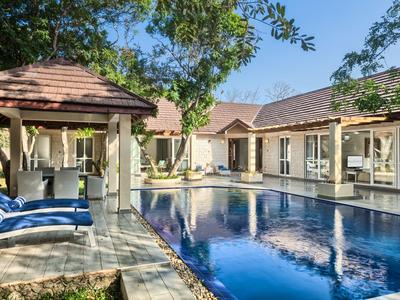 Moderner Poolbereich mit Liegestühlen und überdachter Lounge in einem Hotel bei sonnigem Wetter
