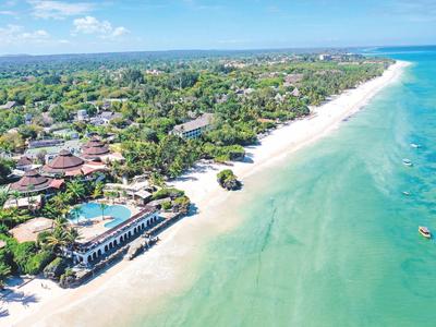 Luftaufnahme eines Resorts mit Strand, Pool und türkisfarbenem Meer.