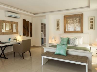 Helles Hotelzimmer mit Doppelbett, gemütlicher Sitzgelegenheit und modernem Dekor.