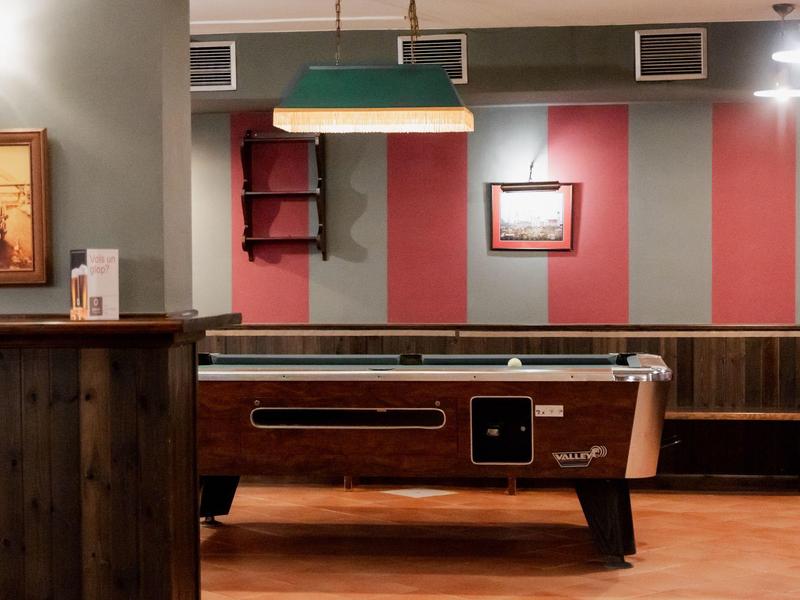 Ein Billardtisch in einem gemütlichen Raum mit Holzwänden und Streifen an der Wand.