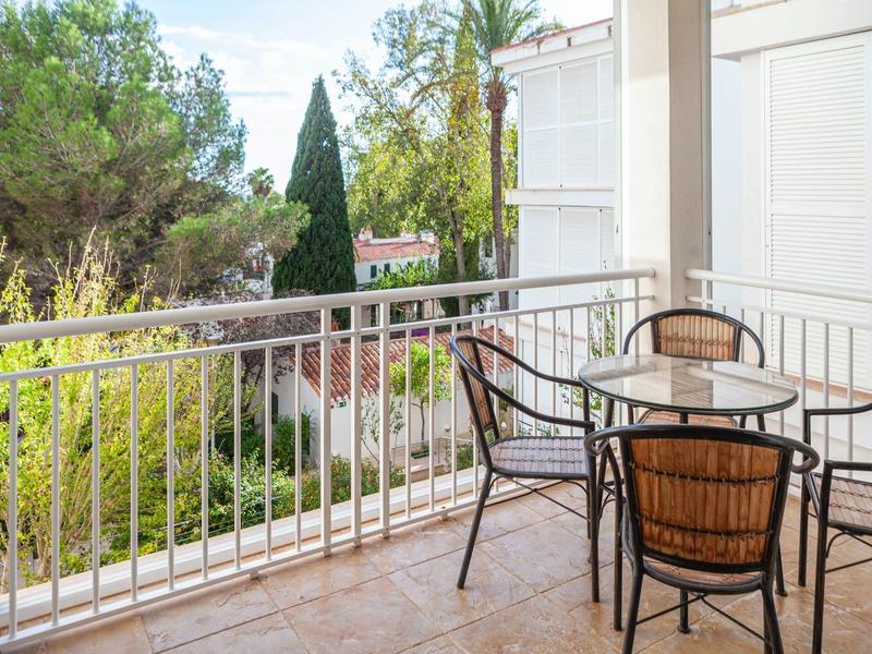 Balkon mit Rattanstühlen und Gartenausblick bei Tageslicht