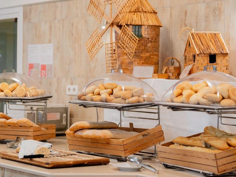 Buffet mit verschiedenen Brotsorten und dekorativen Holzvogelhäusern im Hintergrund