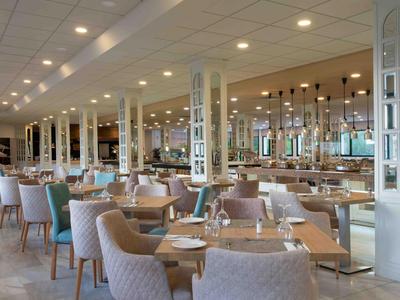 Ampia ed elegante sala da pranzo dell'hotel con tavoli apparecchiati e sedie confortevoli.