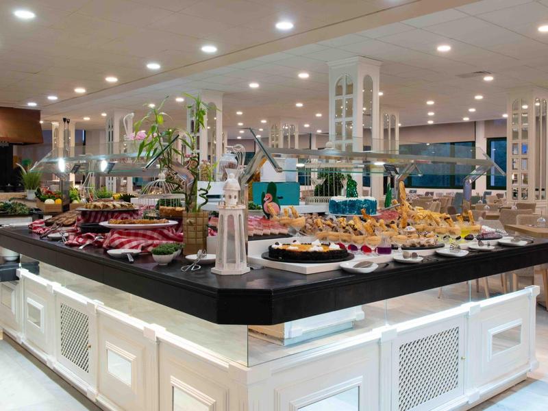 Buffet con vari piatti in un ristorante moderno e ben illuminato.