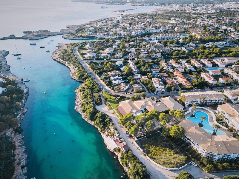 Luchtfoto van een kusthotel met turquoise water en omliggende stad