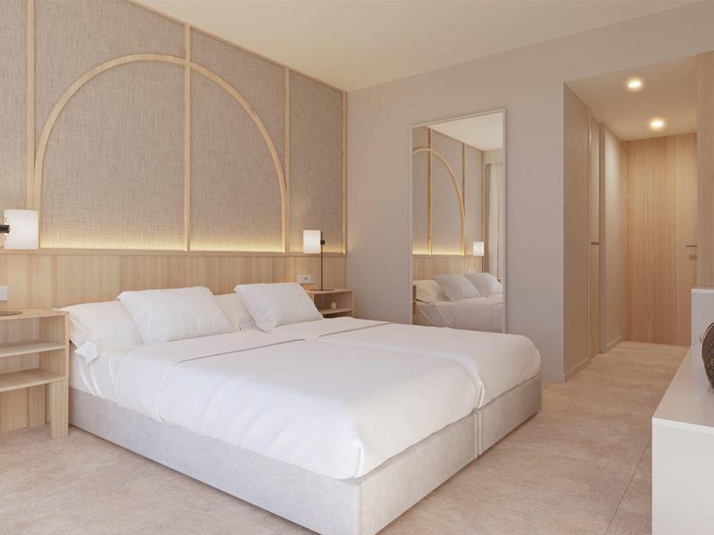 Modern hotelkamer met een groot bed, licht hout, spiegel en subtiele verlichting.