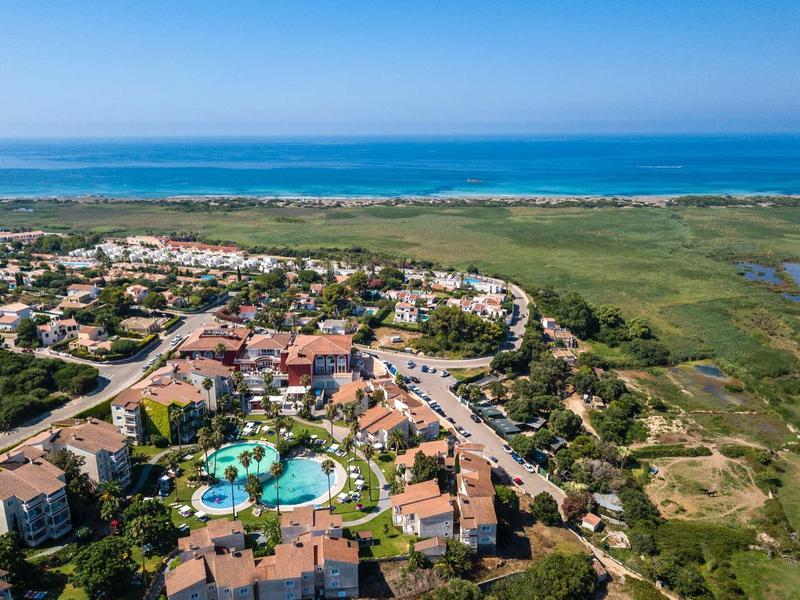Vue aérienne d'un hôtel avec piscines près de la côte et vue sur la mer.