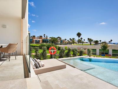Modern balcony with dining table and pool view in a sunny hotel.