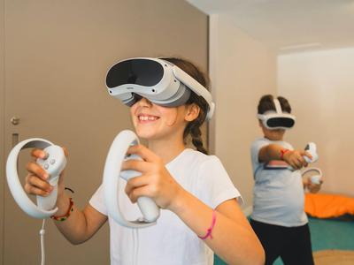 Children using VR headsets with controllers in a bright indoor space for virtual experiences.
