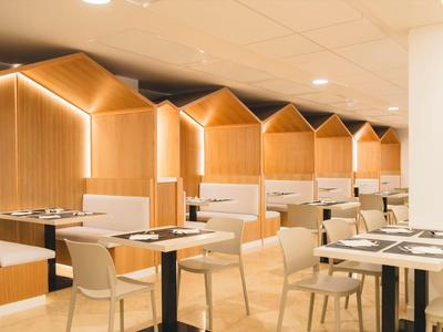 Modern hotel lounge with wooden accents and cozy seating areas under warm lighting.