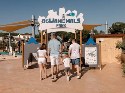 Family entering the Aquanimals water park on a sunny day.