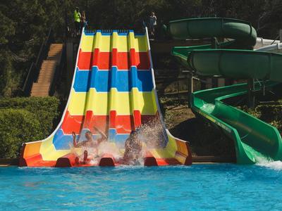 Colorful water slides ending in a pool at a vacation spot.