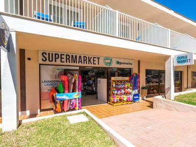 Exterior of a hotel supermarket with umbrellas and beach items outside