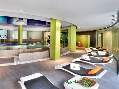 Moderner Wellnessbereich mit Pool, Liegen und entspannter Atmosphäre.