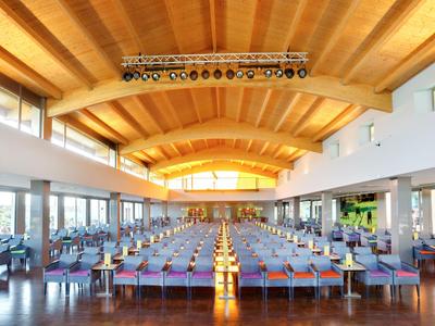 Großer, moderner Speisesaal mit Holzdecke, vielen Tischen und Stühlen, hellem Tageslicht und Fensterfront.