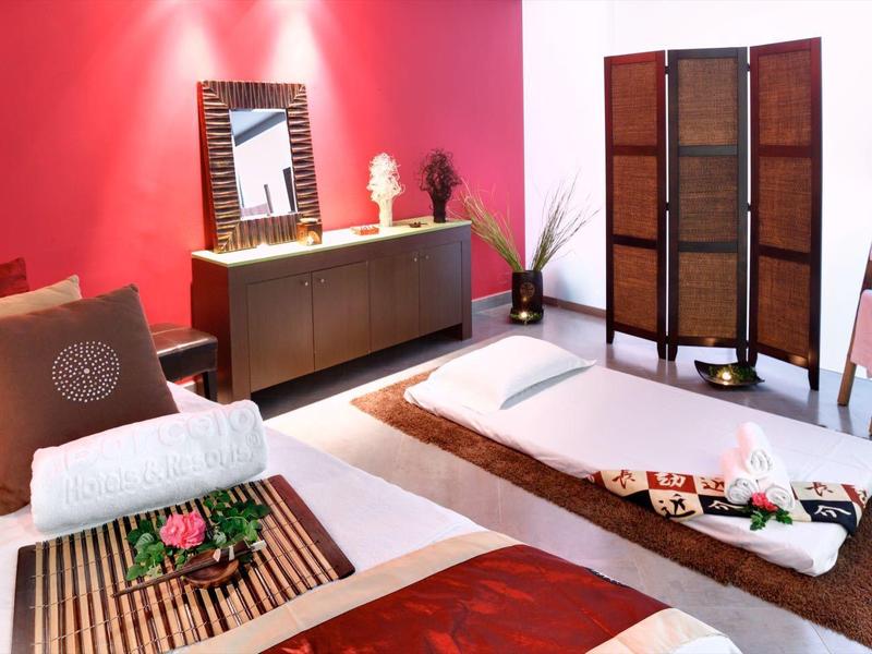 Nowoczesna strefa wellness z łóżkiem do masażu, dekoracjami i relaksującą atmosferą.