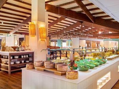 Bufetová oblast s teplými dřevěnými tóny a širokým výběrem jídel v restauraci.