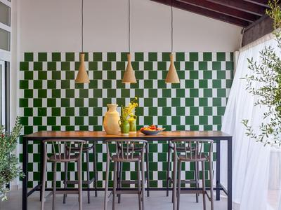 Moderner Frühstücksbereich mit grün-weißer Wand, Holzstühlen und Hängeleuchten.