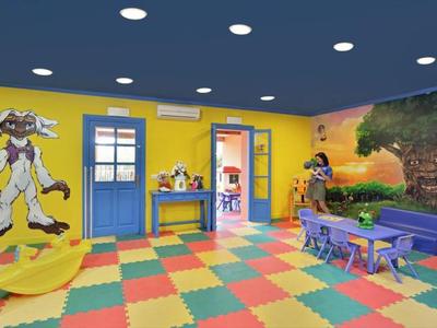 Barevná herna pro děti s kreslenými malbami na zdech, jasným kobercem a hračkami