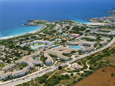 Letecký pohled na velký areál s několika budovami, bazény a přímým přístupem k moři.