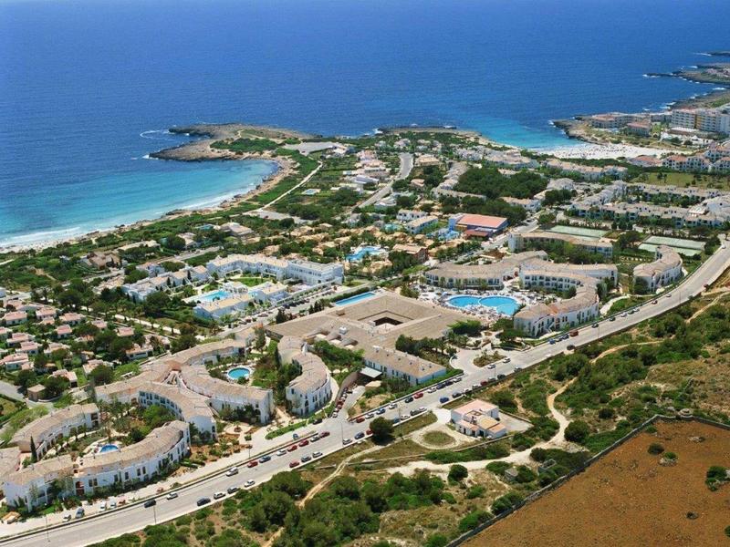 Letecký pohled na velký areál s několika budovami, bazény a přímým přístupem k moři.