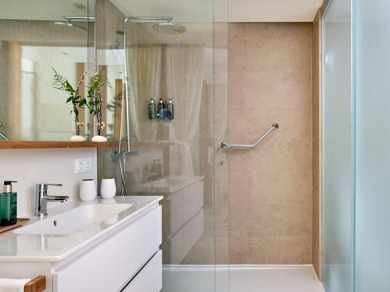 Moderne badkamer met dubbele wasbak, grote spiegel en inloopdouche met glazen deur.