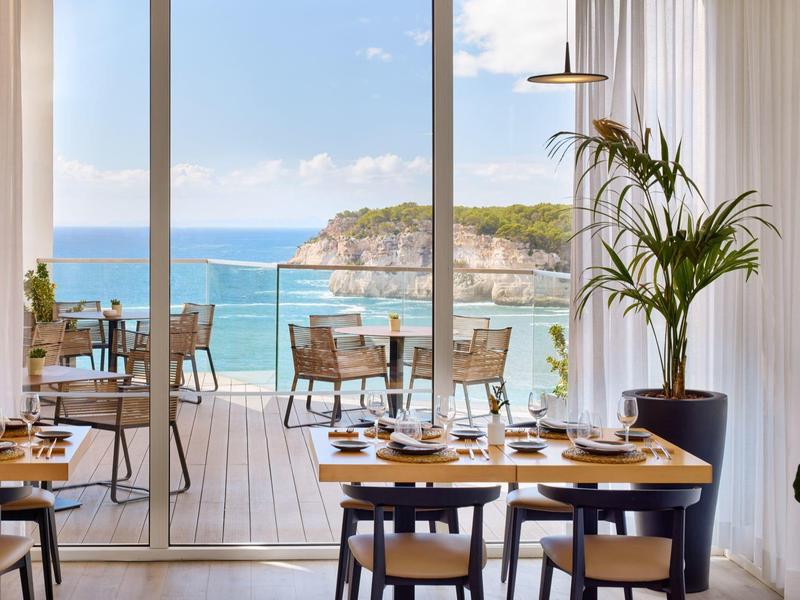 Restaurant met zeezicht en een terras met tafels en stoelen bij daglicht