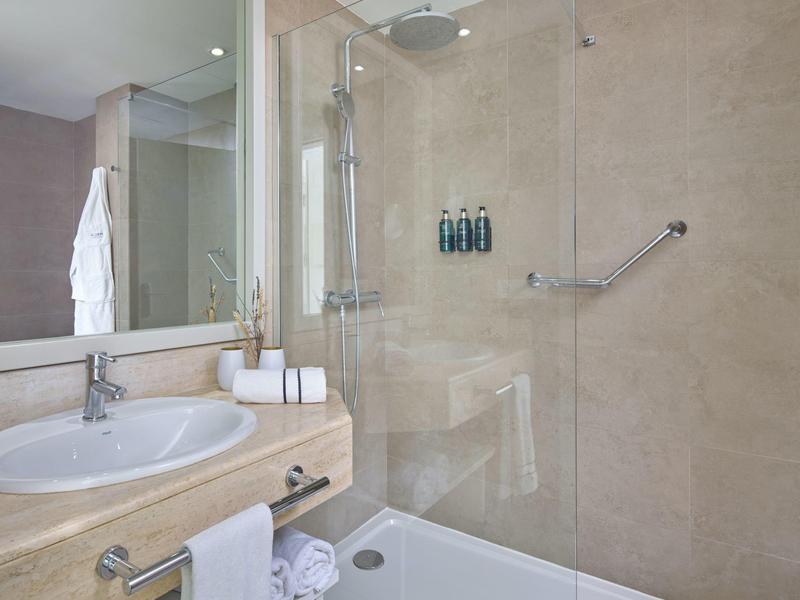 Moderne badkamer met wastafel, badkuip en betegeld douchegedeelte.