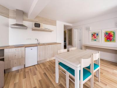 Heller Wohnbereich mit modernes Holzmöbeln, Esstisch, Stühlen und Küchenzeile.