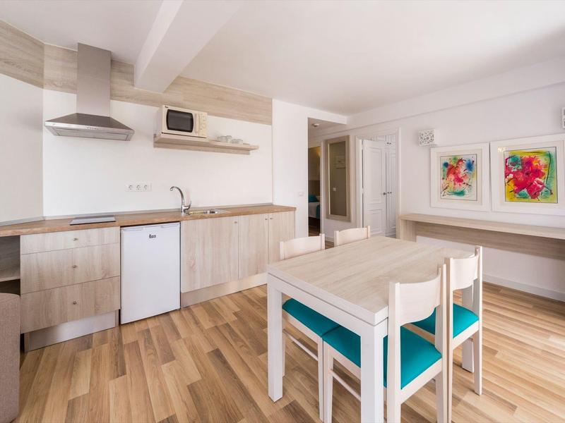 Heller Wohnbereich mit modernes Holzmöbeln, Esstisch, Stühlen und Küchenzeile.